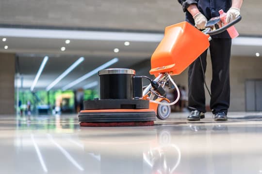 A cleaning technician mopping a floor